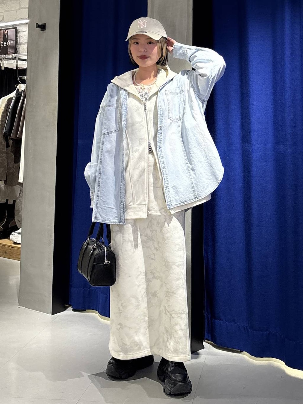 ブラック系のブーツ、ホワイト系のTシャツ/カットソー、ホワイト系のスカートを着用したレディースの冬コーディネートの3枚目の写真