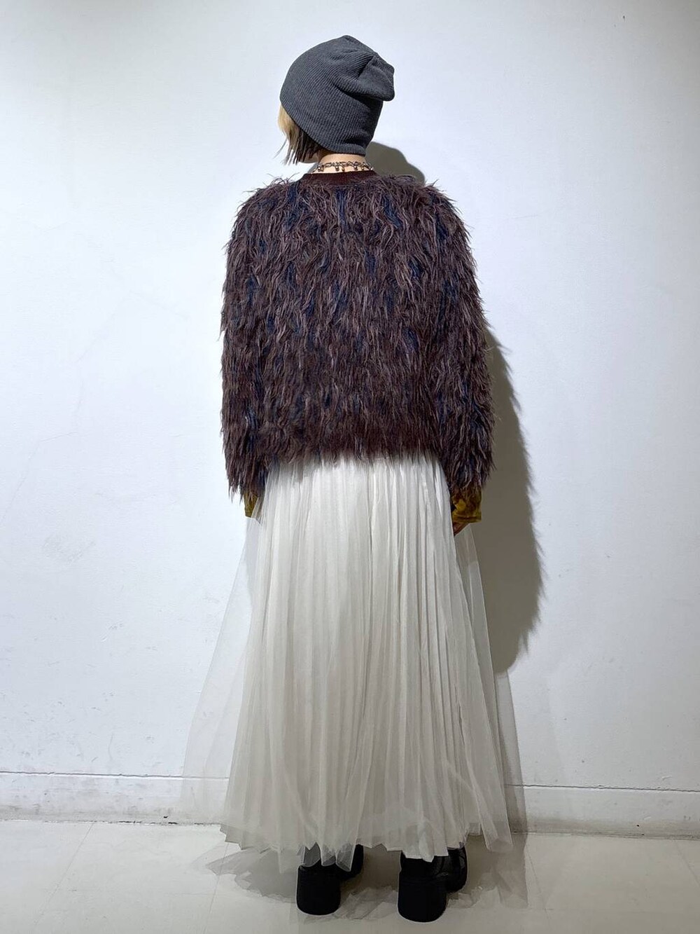 ブラック系のブーツ、ホワイト系のスカート、ブラウン系のカーディガン/ボレロを着用したレディースの冬コーディネートの4枚目の写真