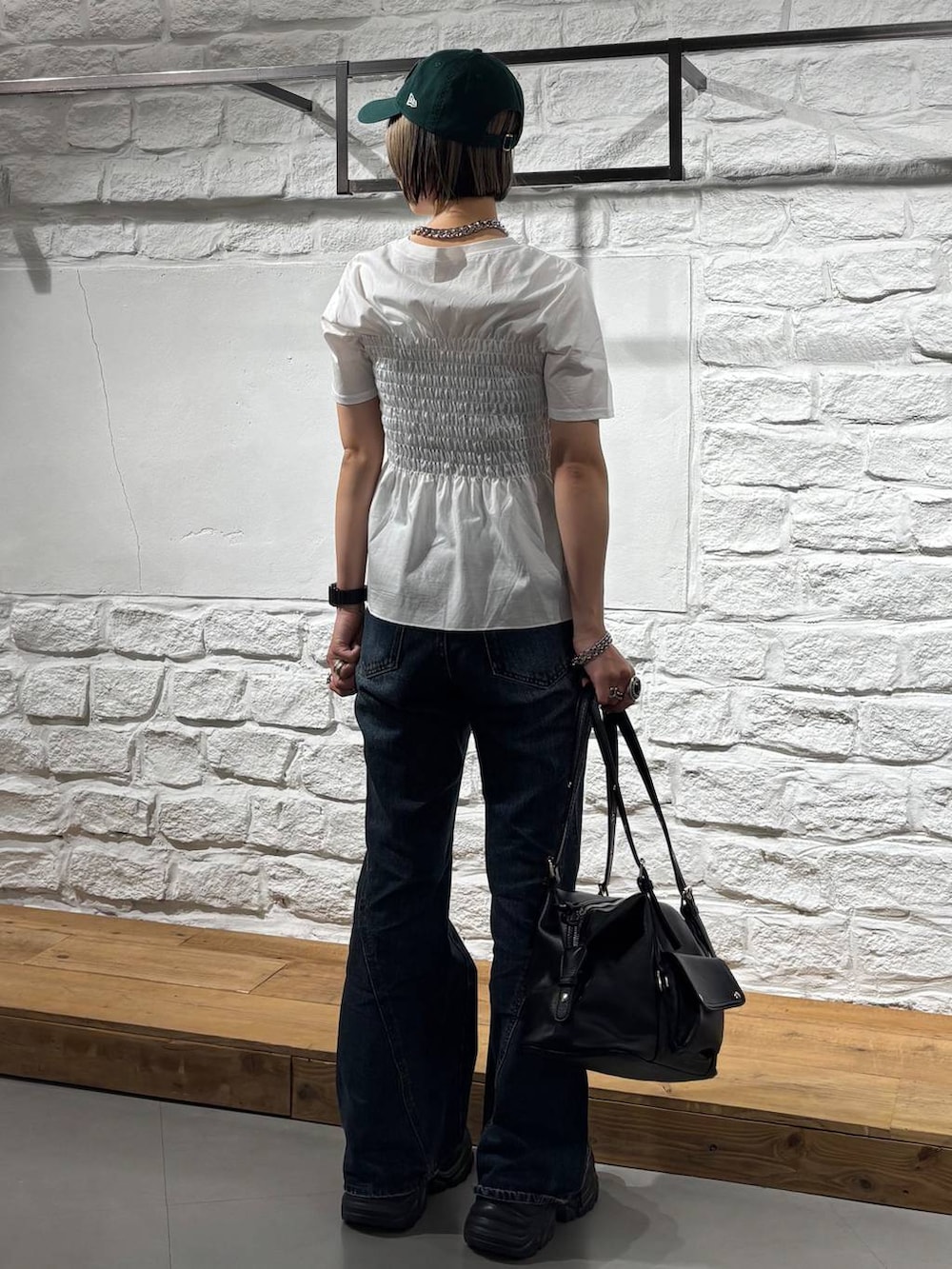 ブラック系のスニーカー、ブルー系のデニムパンツ、ブラック系のボストンバッグを着用したレディースの春コーディネートの5枚目の写真