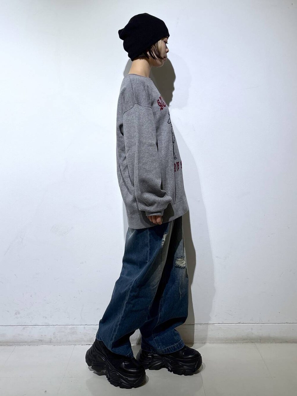 ブラック系のブーツ、ブルー系のデニムパンツ、グレー系のニット/セーターを着用したレディースの秋コーディネートの3枚目の写真