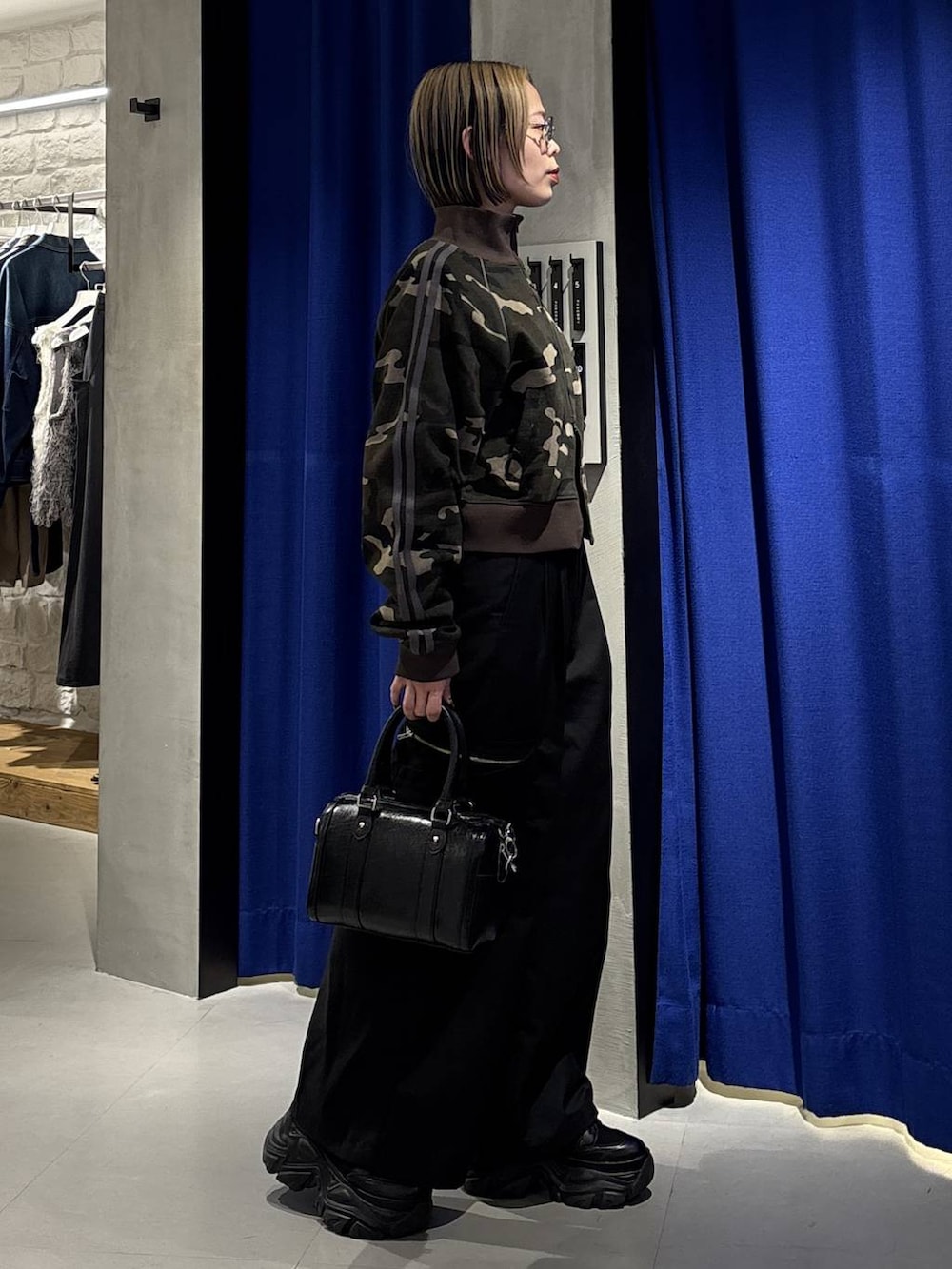 ブラック系のスニーカー、ブラック系のボストンバッグ、ブラック系のスラックスを着用したレディースの冬コーディネートの3枚目の写真