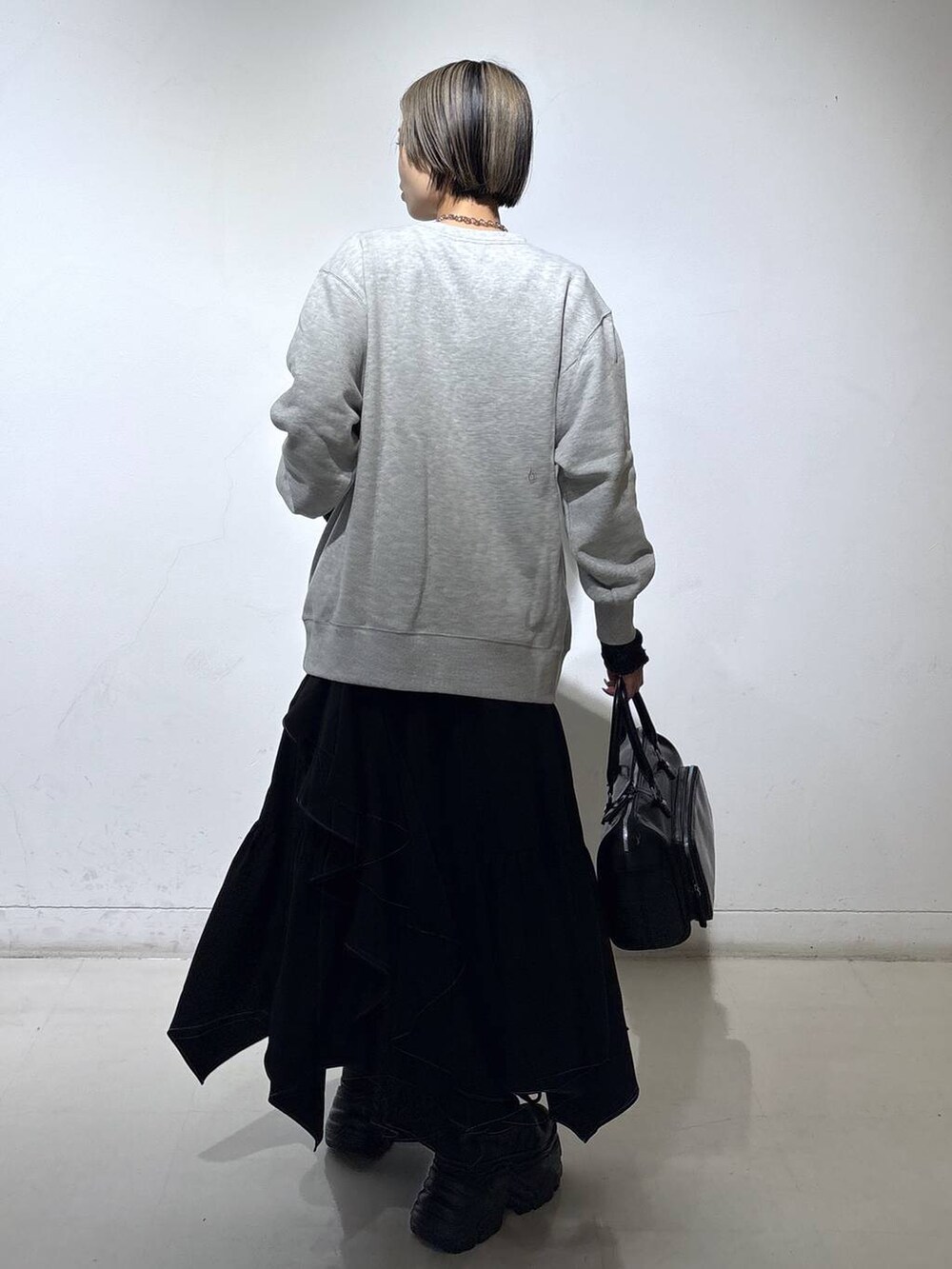 ブラック系のスニーカー、グレー系のスウェット、ブラック系のスカートを着用したレディースの春コーディネートの4枚目の写真