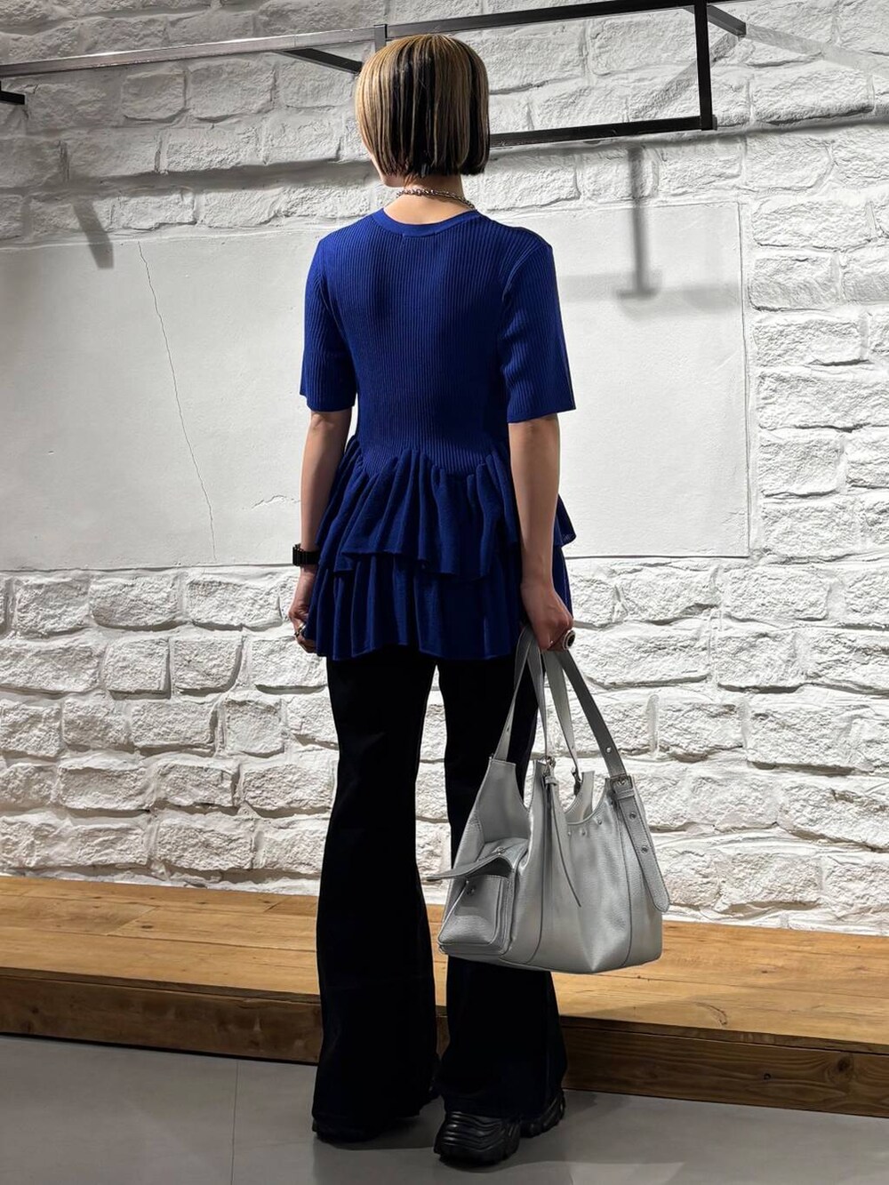 ブラック系のデニムパンツ、グレー系のサンダル、シルバー系のハンドバッグを着用したレディースの春コーディネートの5枚目の写真