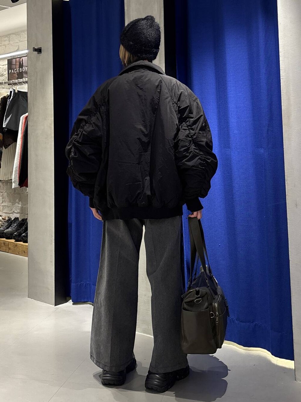 ブラック系のブーツ、グリーン系のボストンバッグ、ブラック系のブルゾンを着用したレディースの冬コーディネートの4枚目の写真