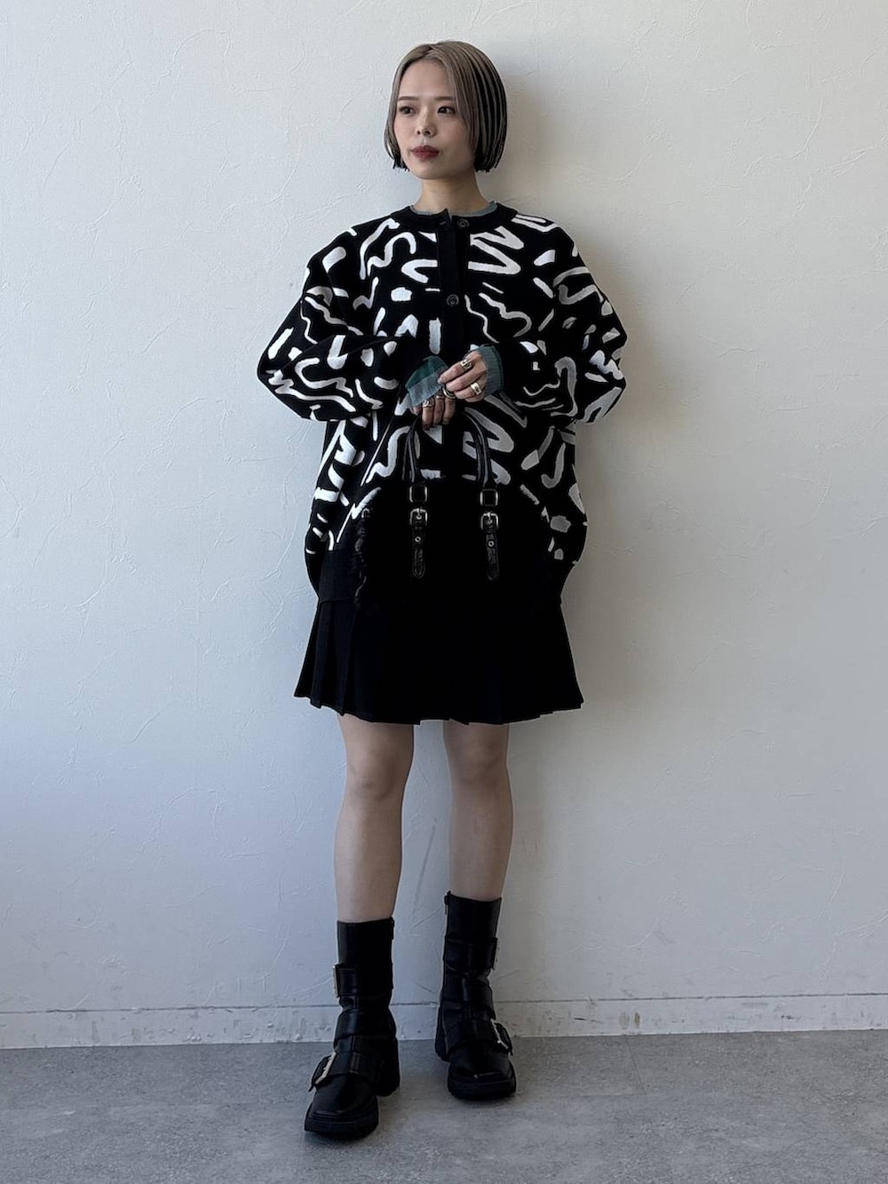 ブラック系のブーツ、ブラック系のボストンバッグ、ブラック系のその他パンツを着用したレディースの冬コーディネートの3枚目の写真