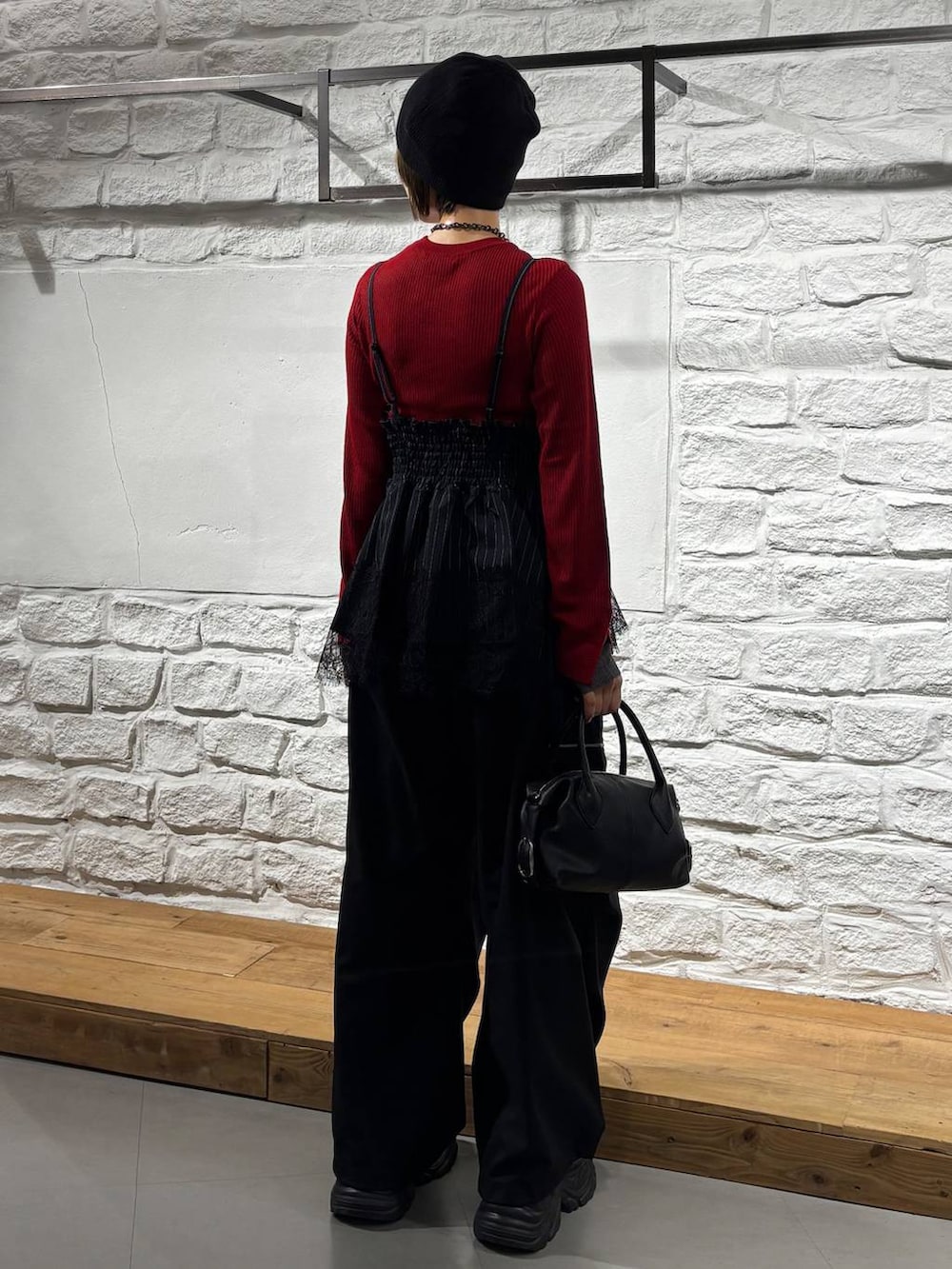 ブラック系のカーゴパンツ、レッド系のニット/セーター、ブラック系のスニーカーを着用したレディースの秋コーディネートの6枚目の写真