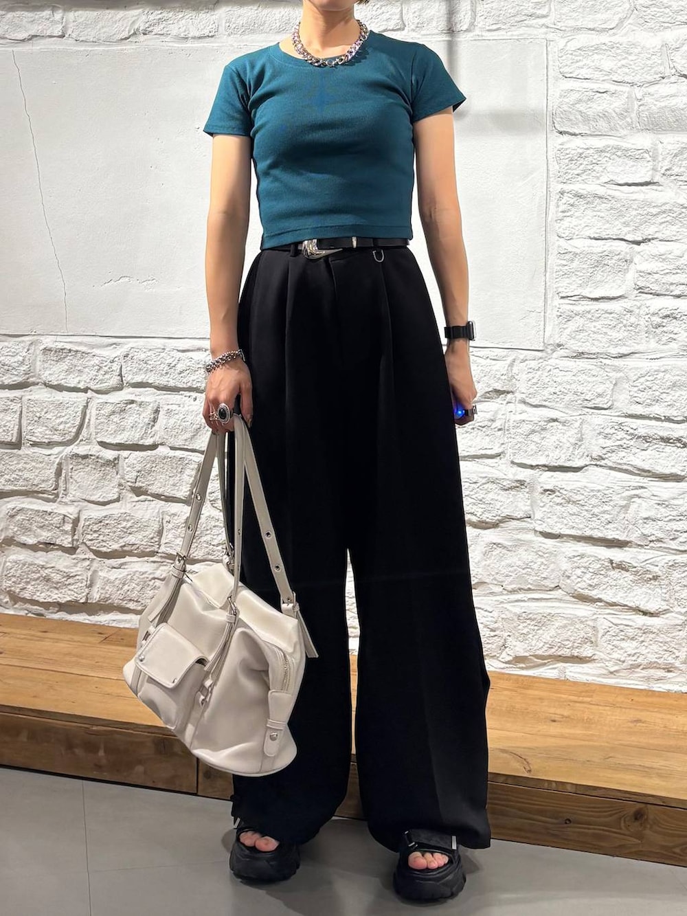 グレー系のサンダル、ホワイト系のボストンバッグ、グリーン系のTシャツ/カットソーを着用したレディースの夏コーディネートの3枚目の写真