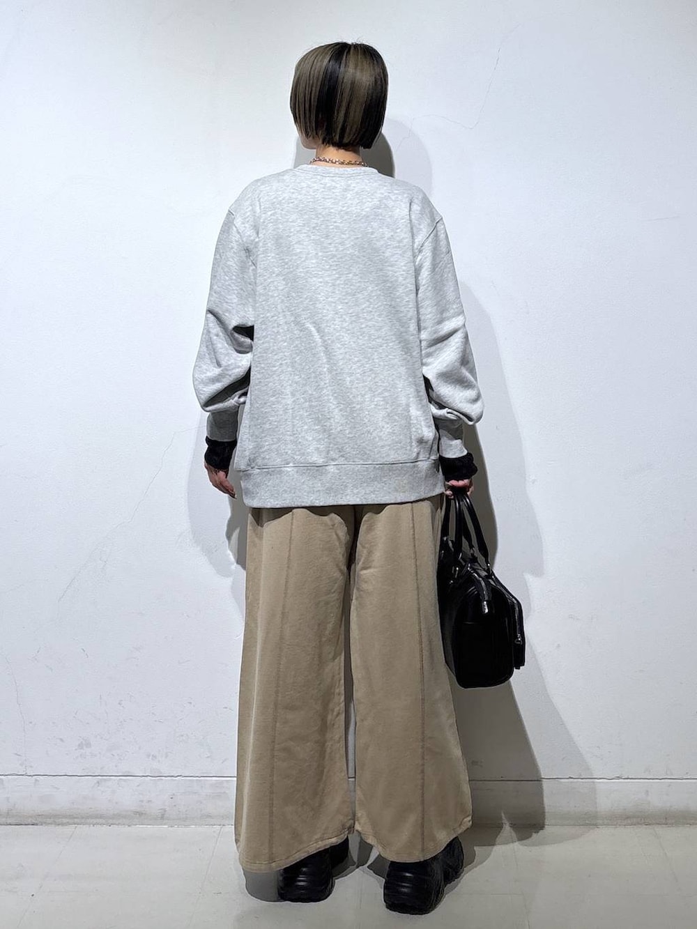 ブラック系のスニーカー、ブラック系のTシャツ/カットソー、グレー系のスウェットを着用したレディースの春コーディネートの5枚目の写真