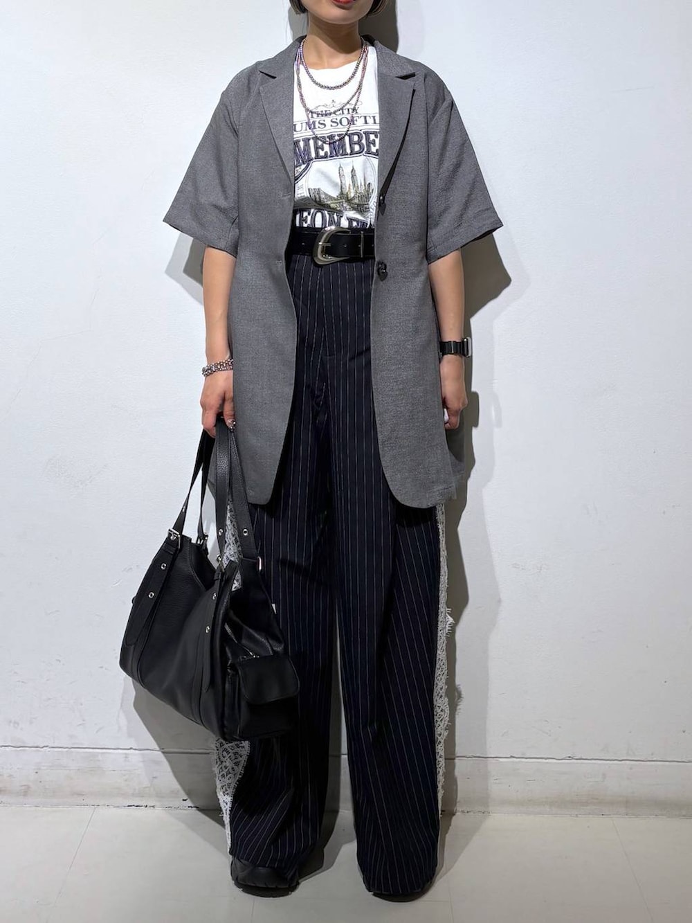 ブラック系のサンダル、グレー系のテーラードジャケット、ホワイト系のTシャツ/カットソーを着用したレディースの夏コーディネートの3枚目の写真