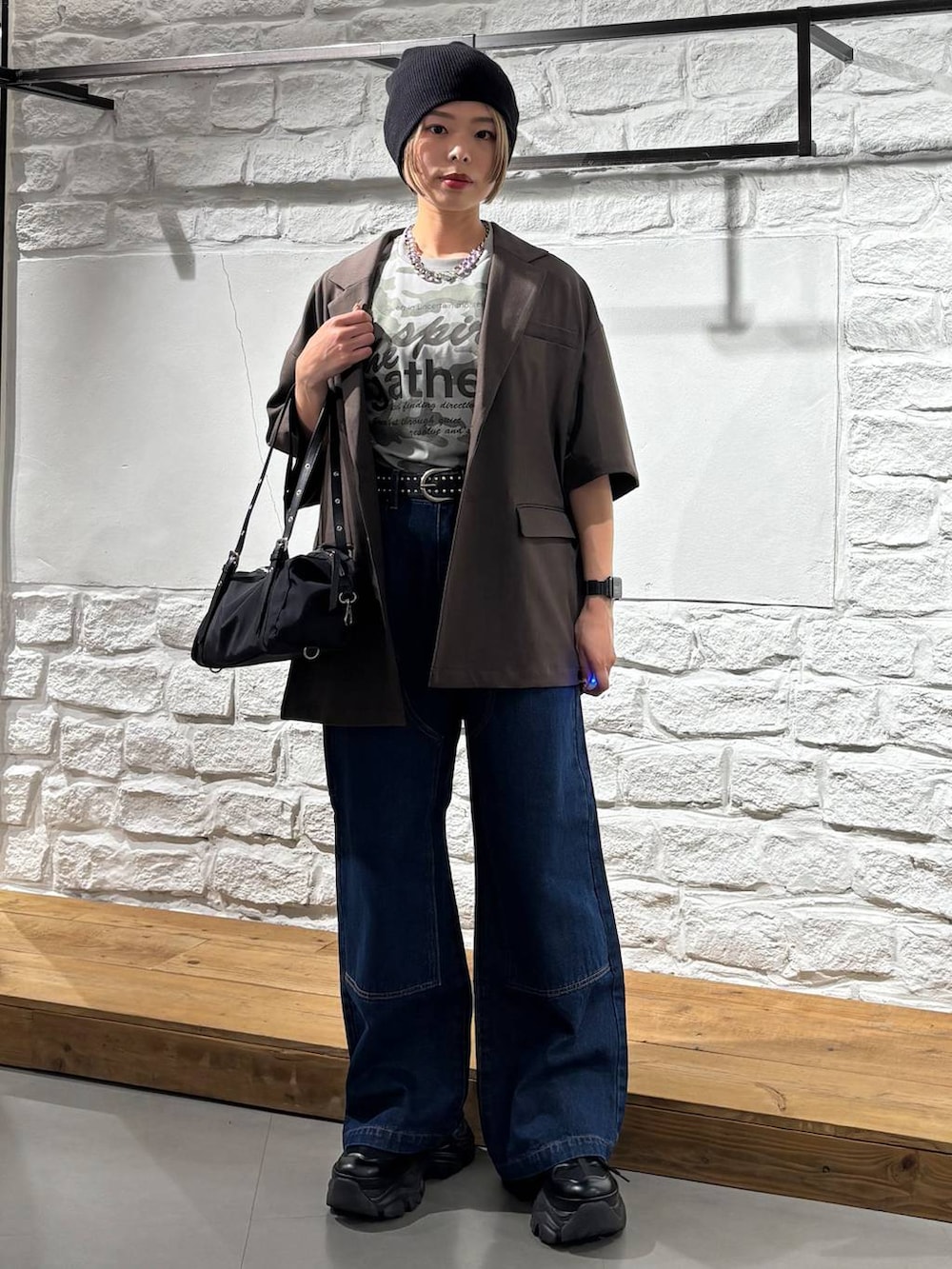 ブラック系のスニーカー、ブルー系のデニムパンツ、その他のTシャツ/カットソーを着用したレディースの春コーディネートの2枚目の写真