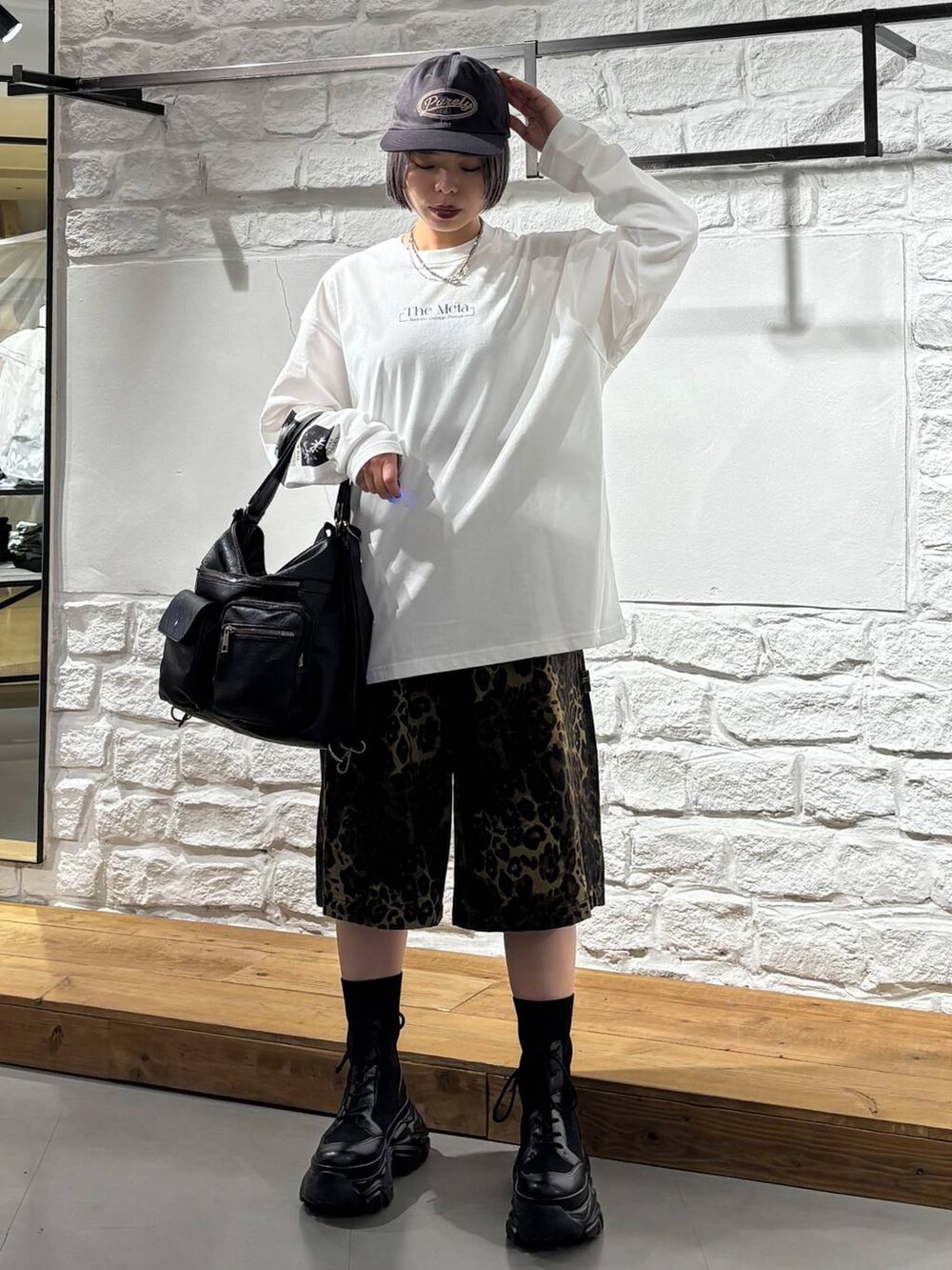 ブラック系のブーツ、その他のデニムパンツ、ブラック系のショルダーバッグを着用したレディースの春コーディネートの2枚目の写真