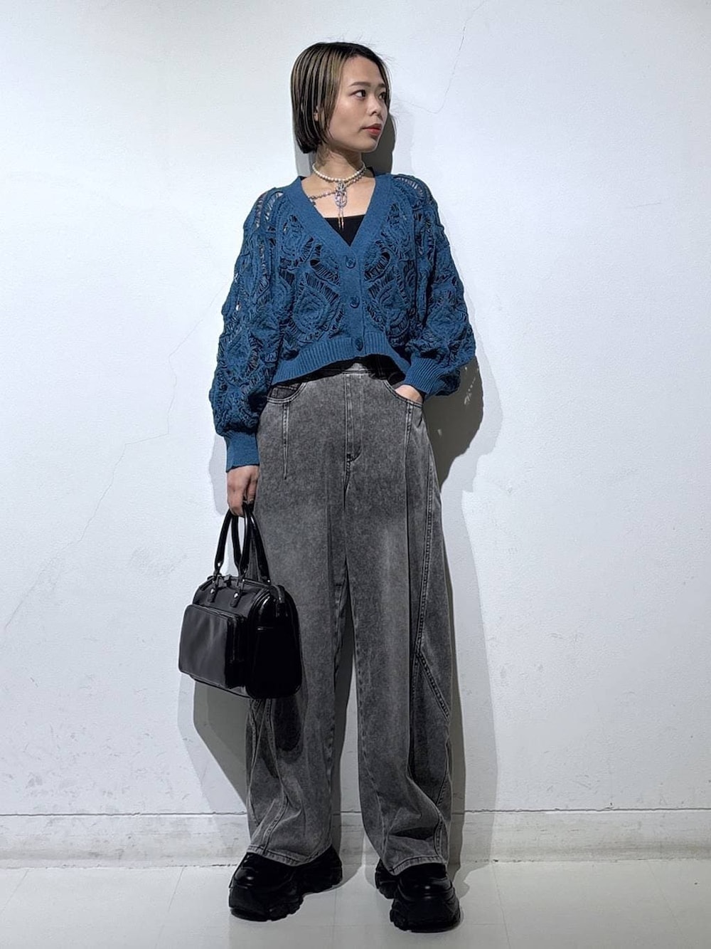 ブラック系のスニーカー、ブラック系のキャミソール、ブルー系のカーディガン/ボレロを着用したレディースの春コーディネートの2枚目の写真