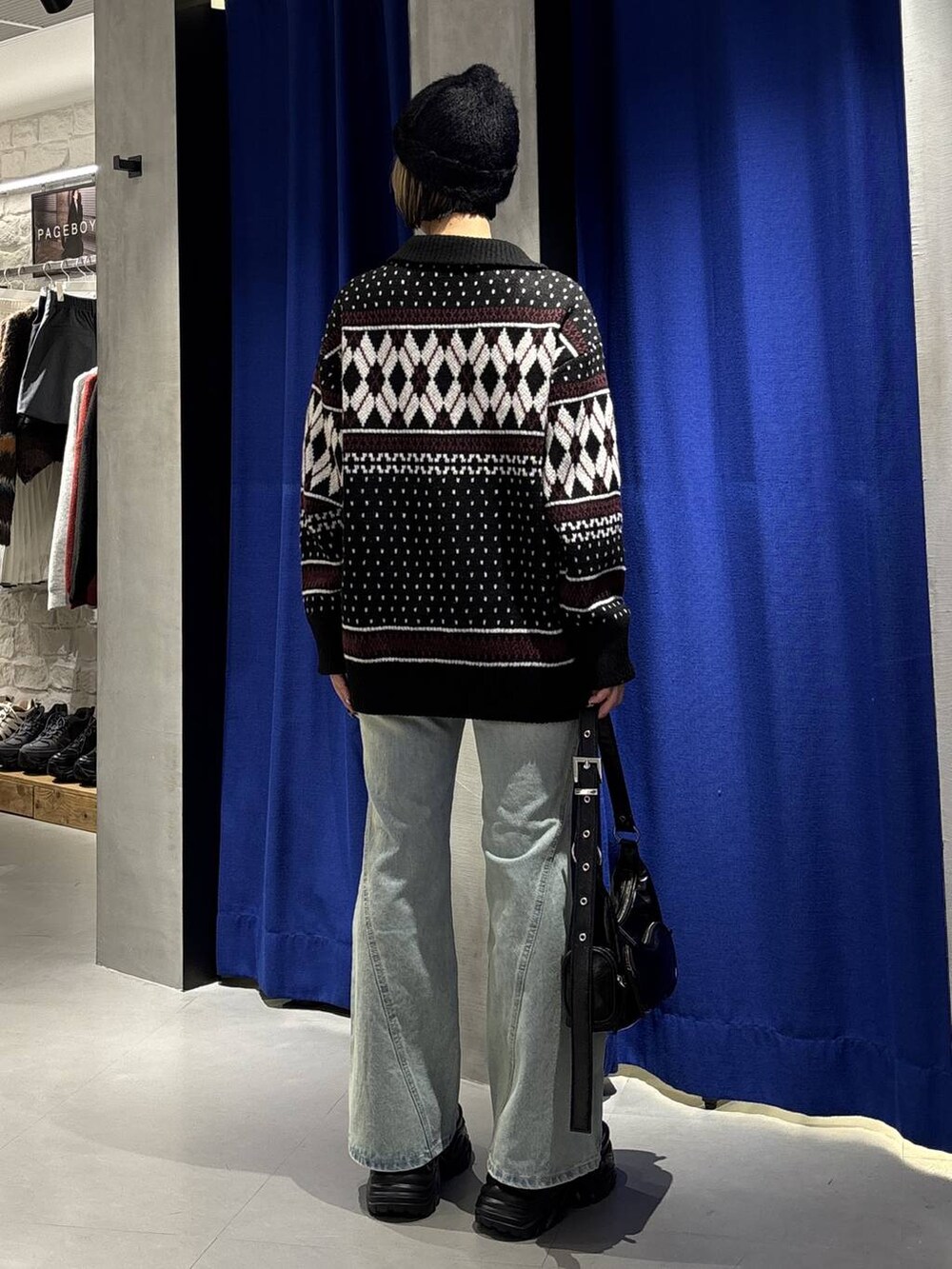 ブラック系のブーツ、ブルー系のデニムパンツ、ブラック系のショルダーバッグを着用したレディースの冬コーディネートの4枚目の写真