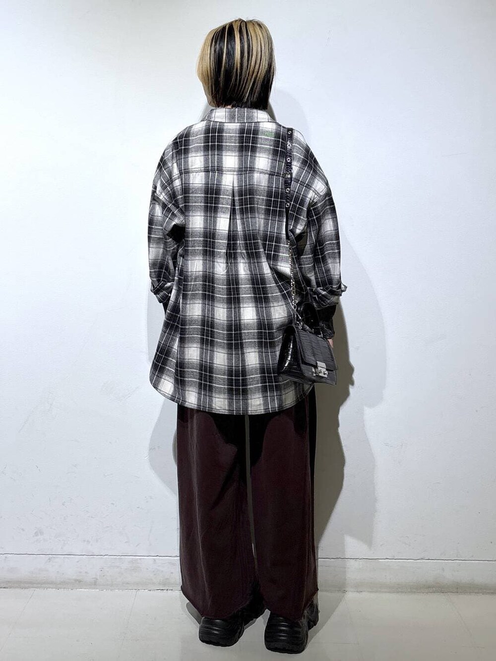 ブラック系のブーツ、シルバー系のTシャツ/カットソー、ブラウン系のスウェットパンツを着用したレディースの秋コーディネートの4枚目の写真