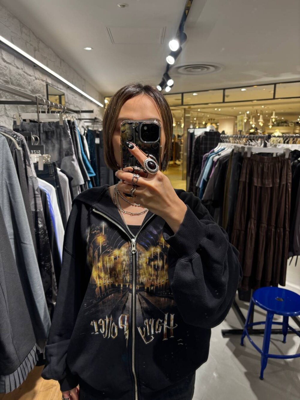 ブラック系のパーカー、ブルー系のデニムパンツを着用したレディースの秋コーディネートの4枚目の写真