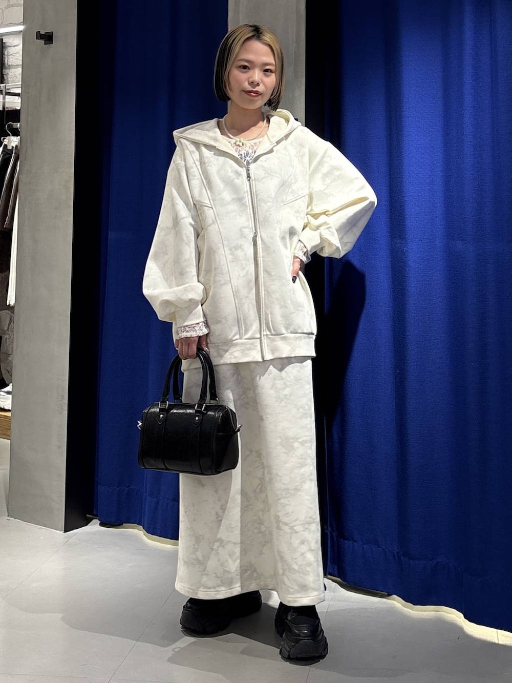 ブラック系のブーツ、ホワイト系のTシャツ/カットソー、ホワイト系のスカートを着用したレディースの冬コーディネートの3枚目の写真