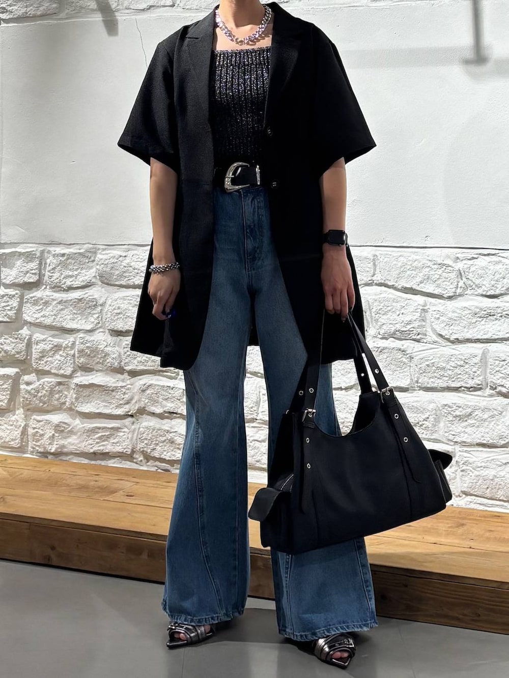 ブルー系のデニムパンツ、ブラック系のタンクトップ、その他のサンダルを着用したレディースの春コーディネートの3枚目の写真
