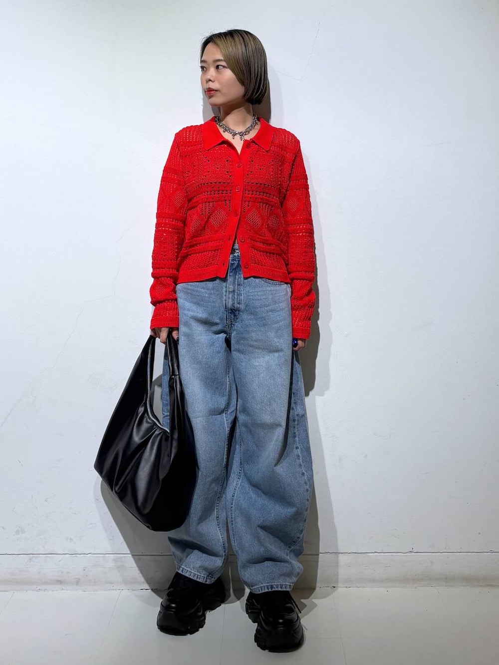 ブラック系のスニーカー、ブラック系のキャミソール、ブルー系のデニムパンツを着用したレディースの春コーディネートの2枚目の写真