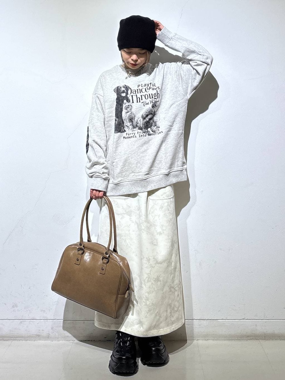 ブラック系のスニーカー、ベージュ系のボストンバッグ、ホワイト系のスカートを着用したレディースの冬コーディネートの5枚目の写真