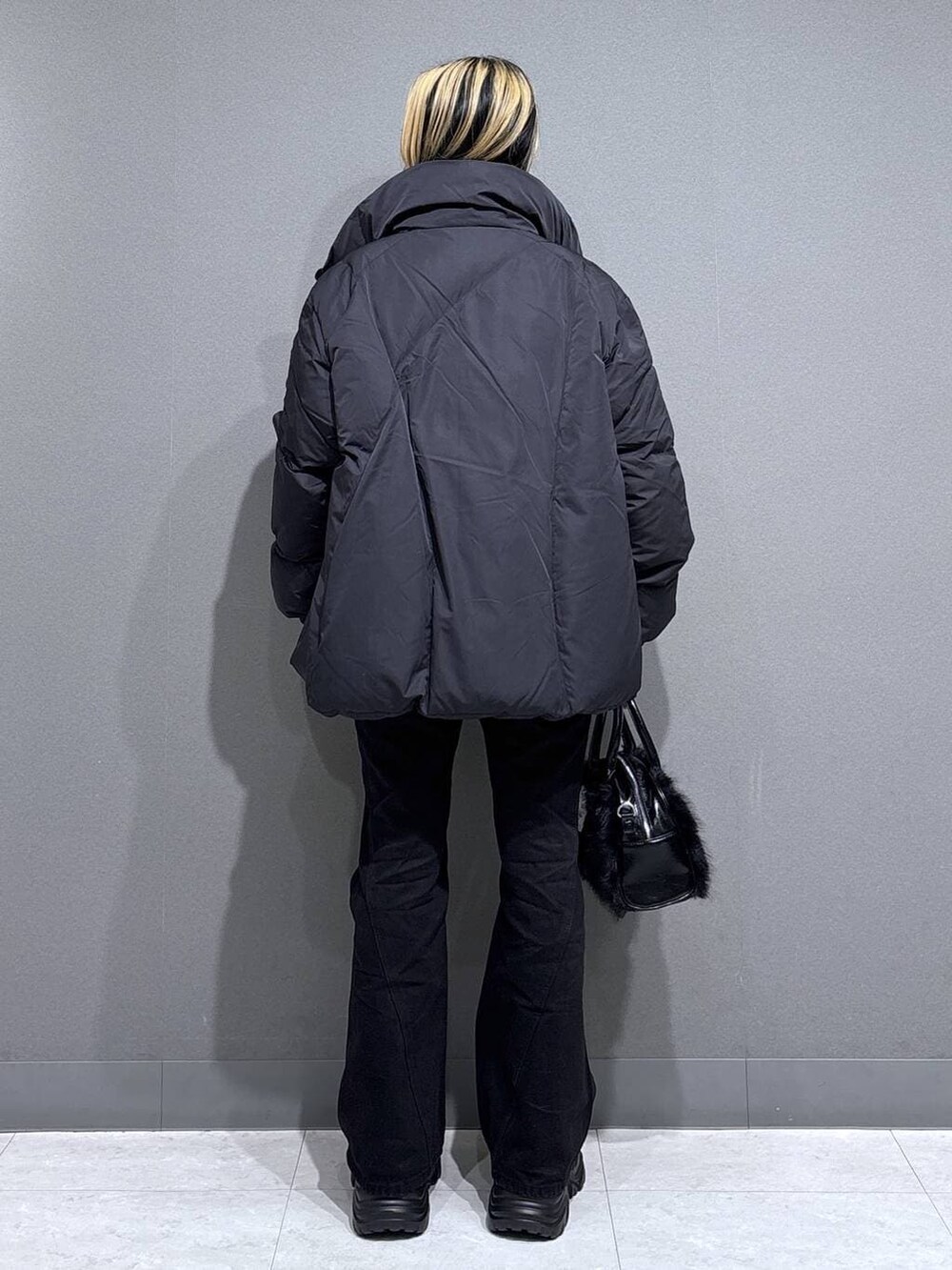 ブラック系のブーツ、ブラック系のデニムパンツ、ブラック系のブルゾンを着用したレディースの冬コーディネートの4枚目の写真