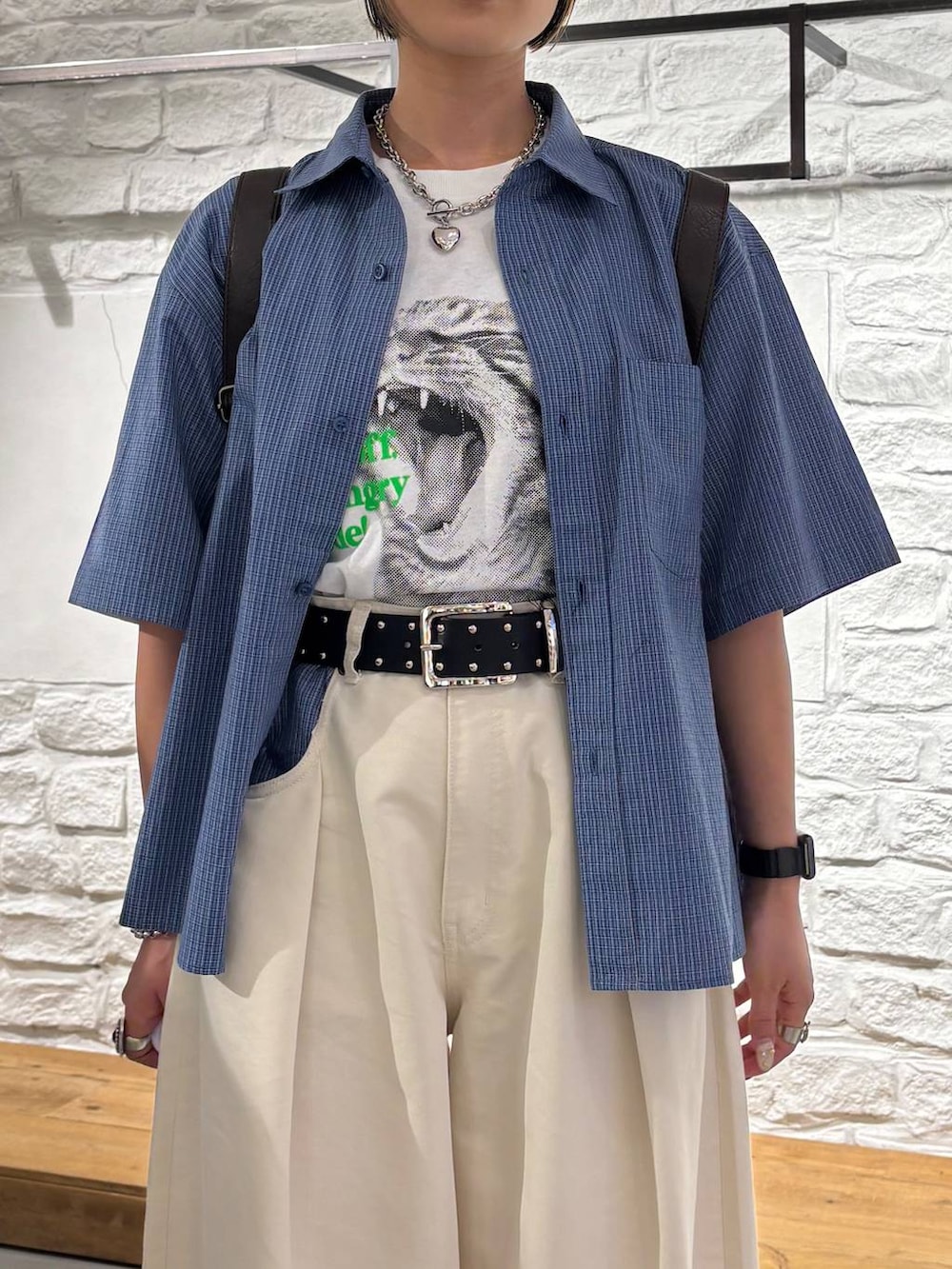 ブルー系のシャツ/ブラウス、ベージュ系のスラックス、ブラック系のスニーカーを着用したレディースの夏コーディネートの3枚目の写真