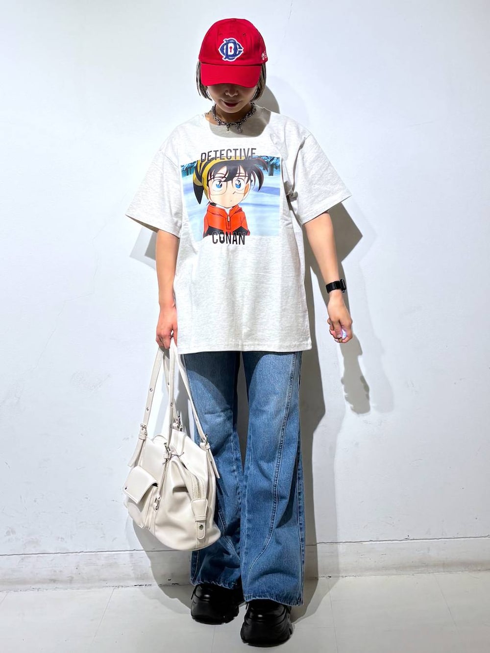 ブラック系のスニーカー、ブルー系のデニムパンツ、ホワイト系のボストンバッグを着用したレディースの春コーディネートの2枚目の写真