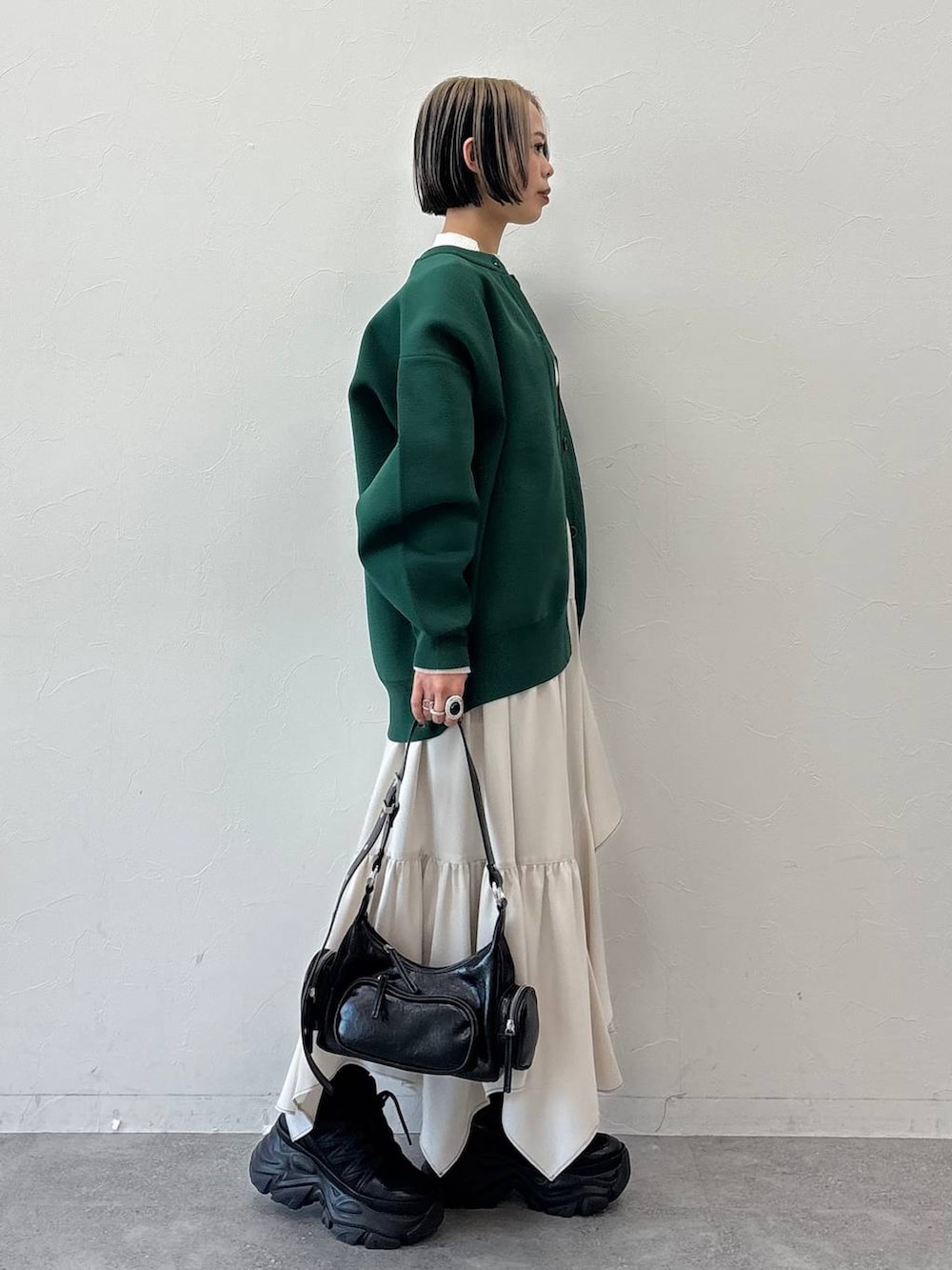 ブラック系のスニーカー、ブラック系のショルダーバッグ、ホワイト系のニット/セーターを着用したレディースの冬コーディネートの6枚目の写真