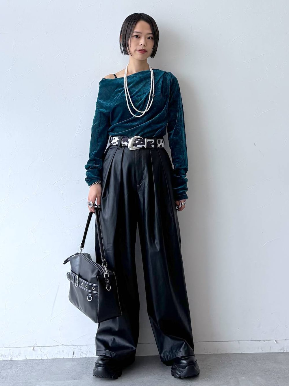 ブラック系のスニーカー、ブラック系のスラックス、ブルー系のTシャツ/カットソーを着用したレディースの秋コーディネートの2枚目の写真