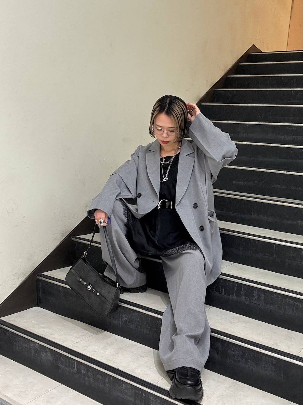 ブラック系のスニーカー、ブラック系のチュニック、ブラック系のハンドバッグを着用したレディースの春コーディネートの8枚目の写真