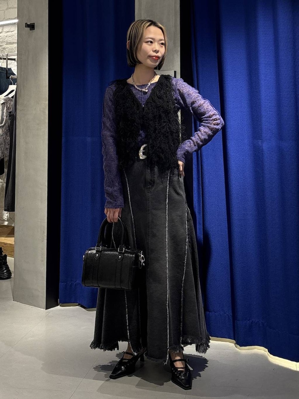 ブラック系のボストンバッグ、ブラック系のサンダル、ブラック系のデニムスカートを着用したレディースの冬コーディネートの3枚目の写真