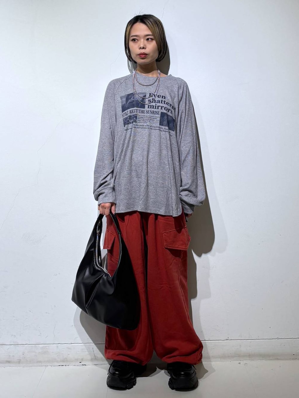 ブラック系のスニーカー、ブラック系のトートバッグ、グレー系のTシャツ/カットソーを着用したレディースの春コーディネートの2枚目の写真