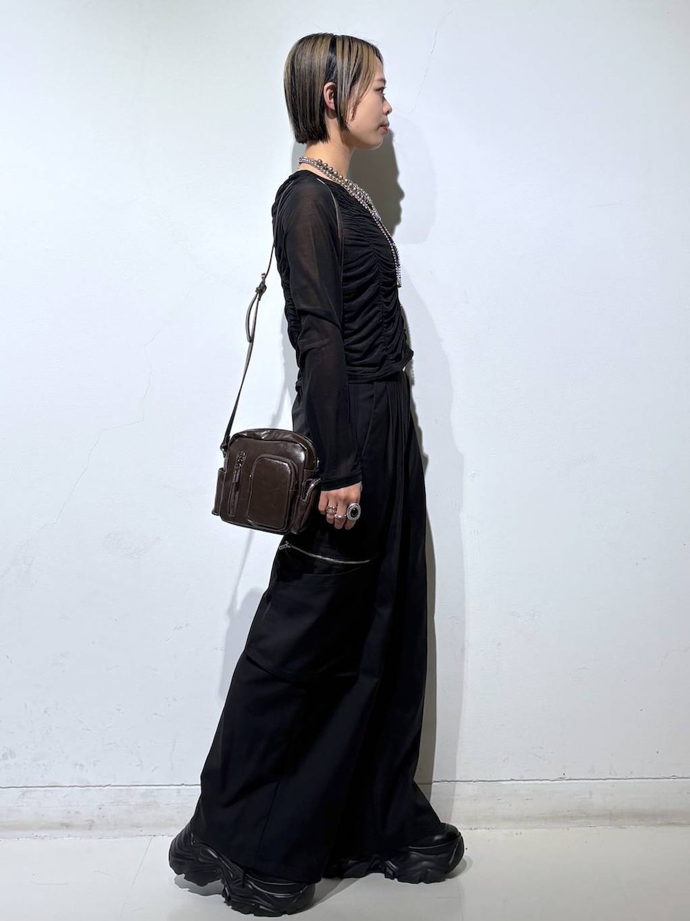 ブラック系のスニーカー、ブラック系のキャミソール、ブラック系のスラックスを着用したレディースの春コーディネートの3枚目の写真