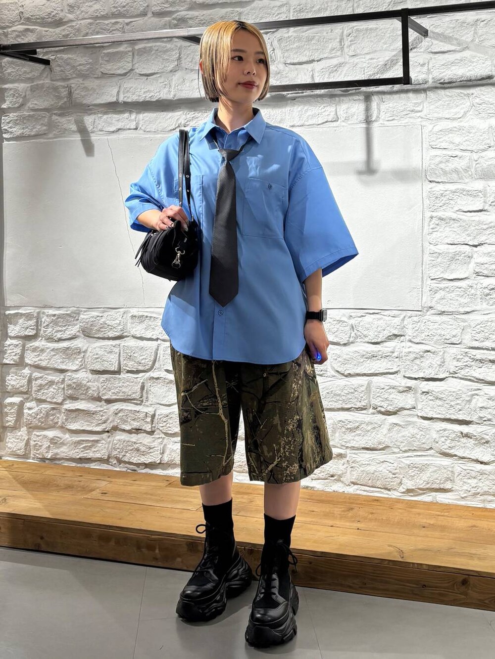 ブラック系のブーツ、その他のデニムパンツ、ブラック系のトートバッグを着用したレディースの春コーディネートの2枚目の写真
