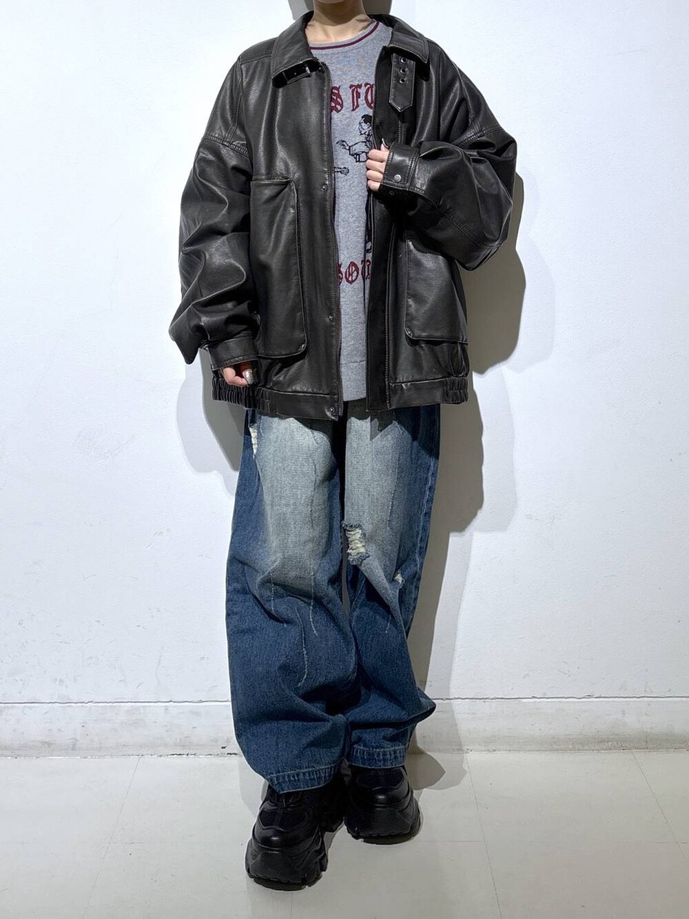 ブラック系のブーツ、ブラック系のブルゾン、グレー系のニット/セーターを着用したレディースの秋コーディネートの2枚目の写真