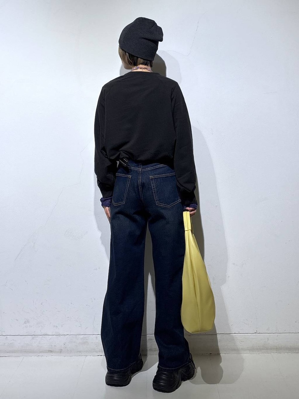 ブラック系のスニーカー、ブルー系のスラックス、イエロー系のトートバッグを着用したレディースの春コーディネートの5枚目の写真