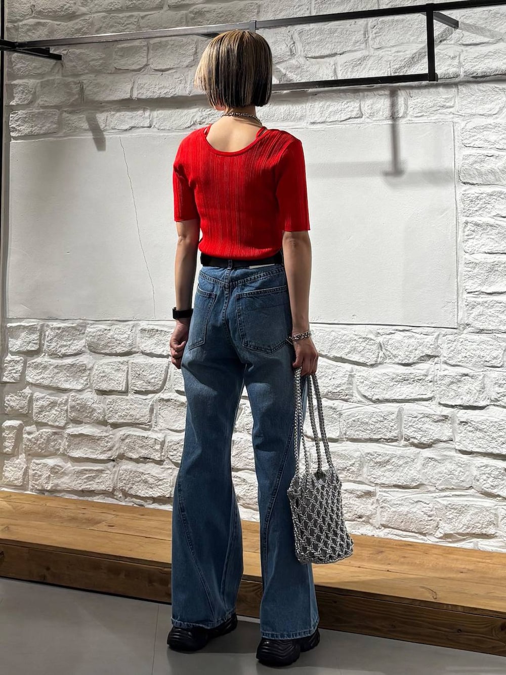 ブルー系のデニムパンツ、ブラック系のサンダル、レッド系のニット/セーターを着用したレディースの春コーディネートの5枚目の写真