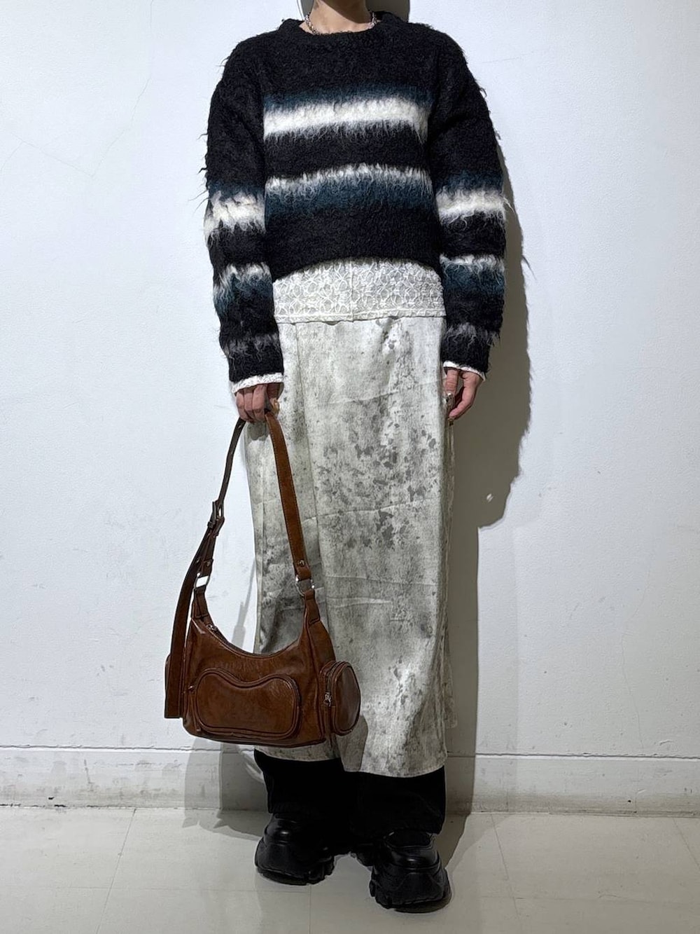 ブラック系のブーツ、ホワイト系のTシャツ/カットソー、ブラウン系のショルダーバッグを着用したレディースの冬コーディネートの2枚目の写真