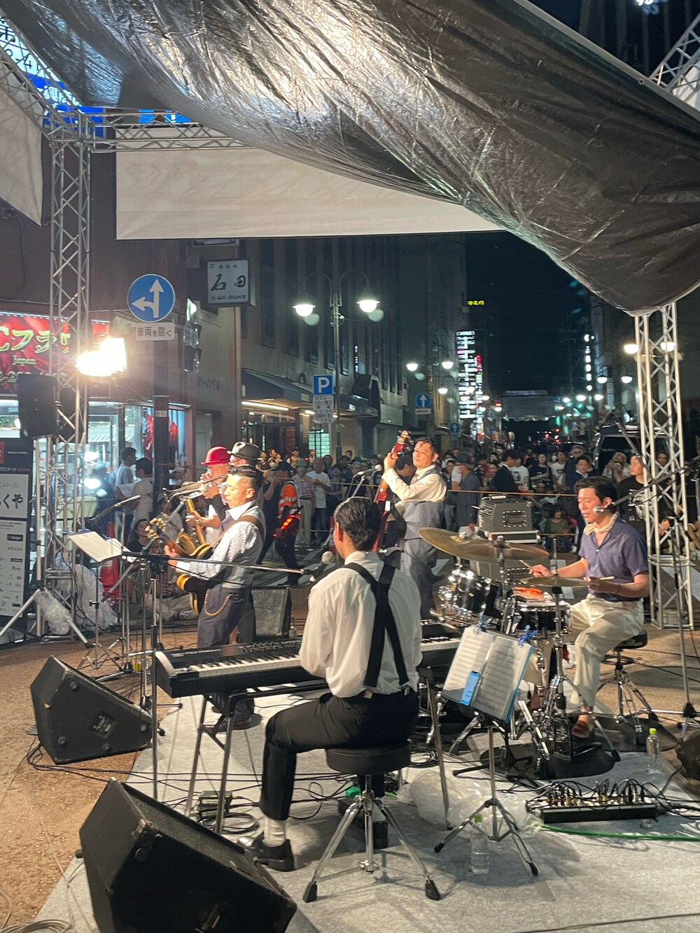 ブラック系のデニムパンツ、グリーン系のニット/セーター、ブラック系のブーツを着用したメンズの春コーディネートの3枚目の写真