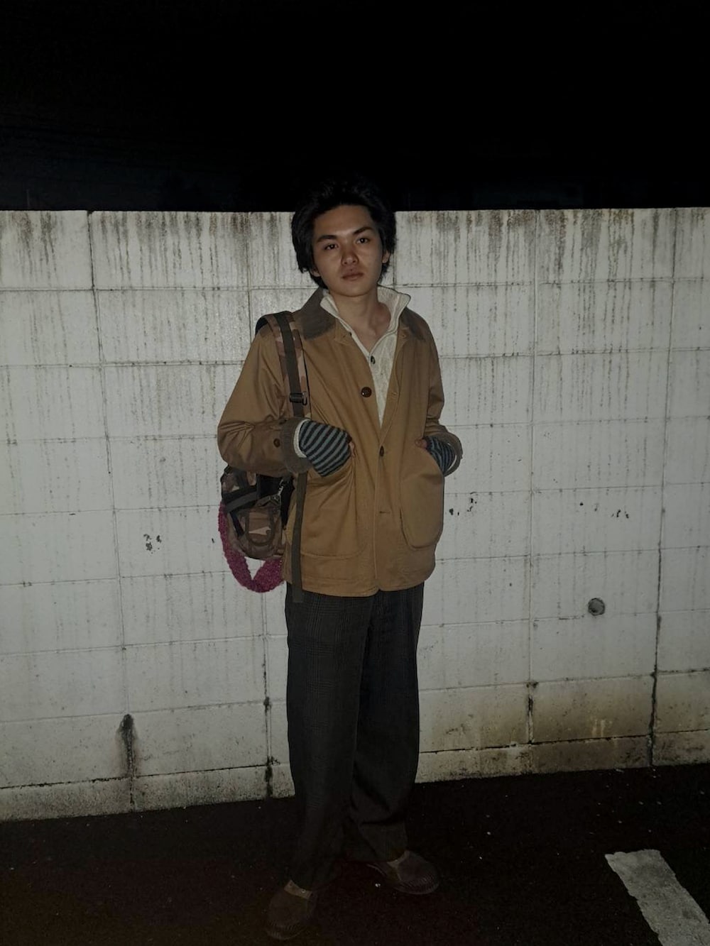 ブラウン系のブーツ、ブラウン系のショルダーバッグを着用したメンズの春コーディネートの2枚目の写真