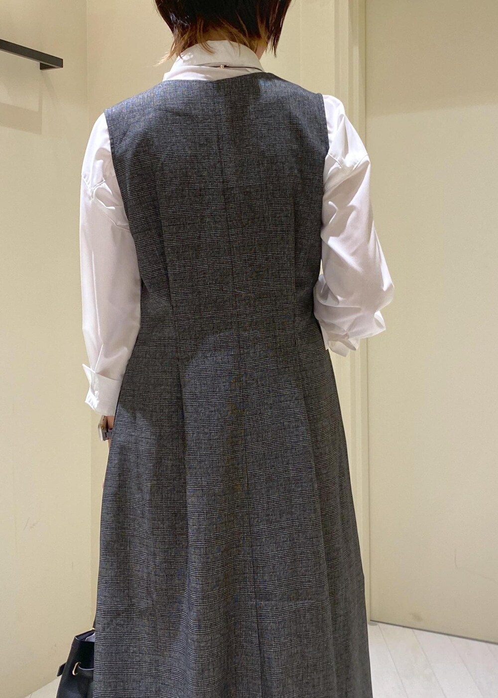 グリーン系のスカート、グレー系のジャンパースカート、ホワイト系のシャツ/ブラウスを着用したレディースの秋コーディネートの7枚目の写真