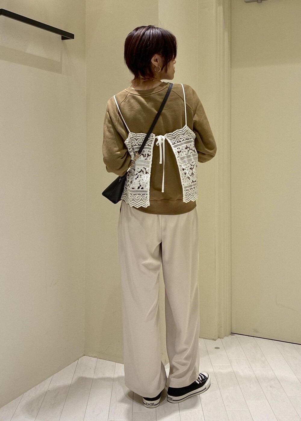 ブラック系のショルダーバッグ、ブラウン系のスウェット、ベージュ系のその他パンツを着用したレディースの春コーディネートの4枚目の写真