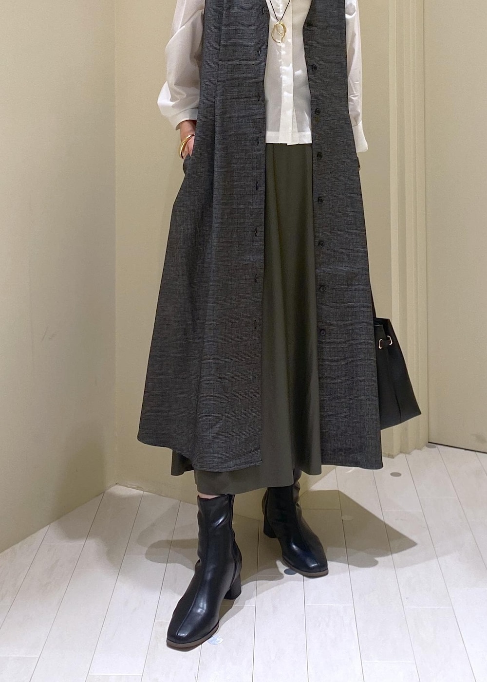 グリーン系のスカート、グレー系のジャンパースカート、ホワイト系のシャツ/ブラウスを着用したレディースの秋コーディネートの8枚目の写真