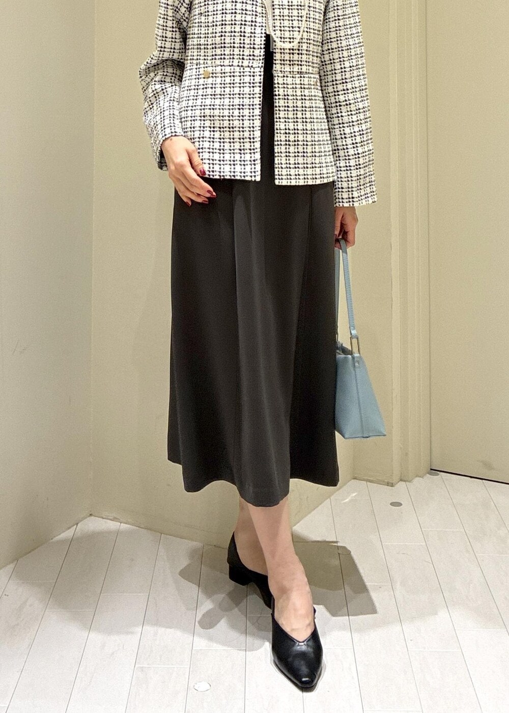 ブラック系のパンプス、ブルー系のショルダーバッグ、グレー系のドレスを着用したレディースの冬コーディネートの7枚目の写真