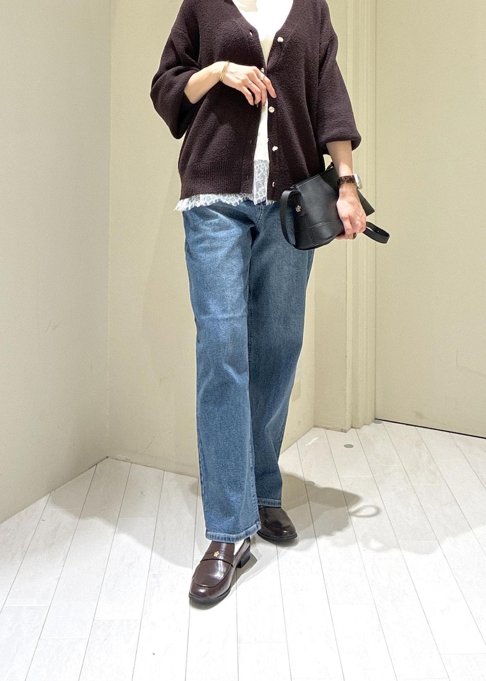 ブラウン系のローファー、ブルー系のデニムパンツ、ホワイト系のキャミソールを着用したレディースの秋コーディネートの2枚目の写真