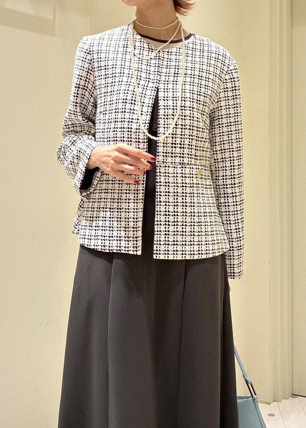 ブラック系のパンプス、ブルー系のショルダーバッグ、グレー系のドレスを着用したレディースの冬コーディネートの4枚目の写真