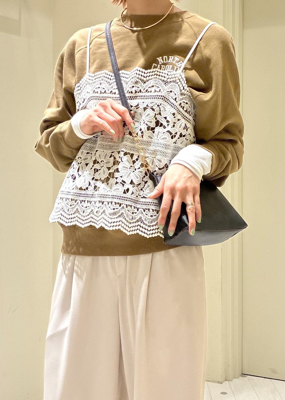 ブラック系のショルダーバッグ、ブラウン系のスウェット、ベージュ系のその他パンツを着用したレディースの春コーディネートの5枚目の写真