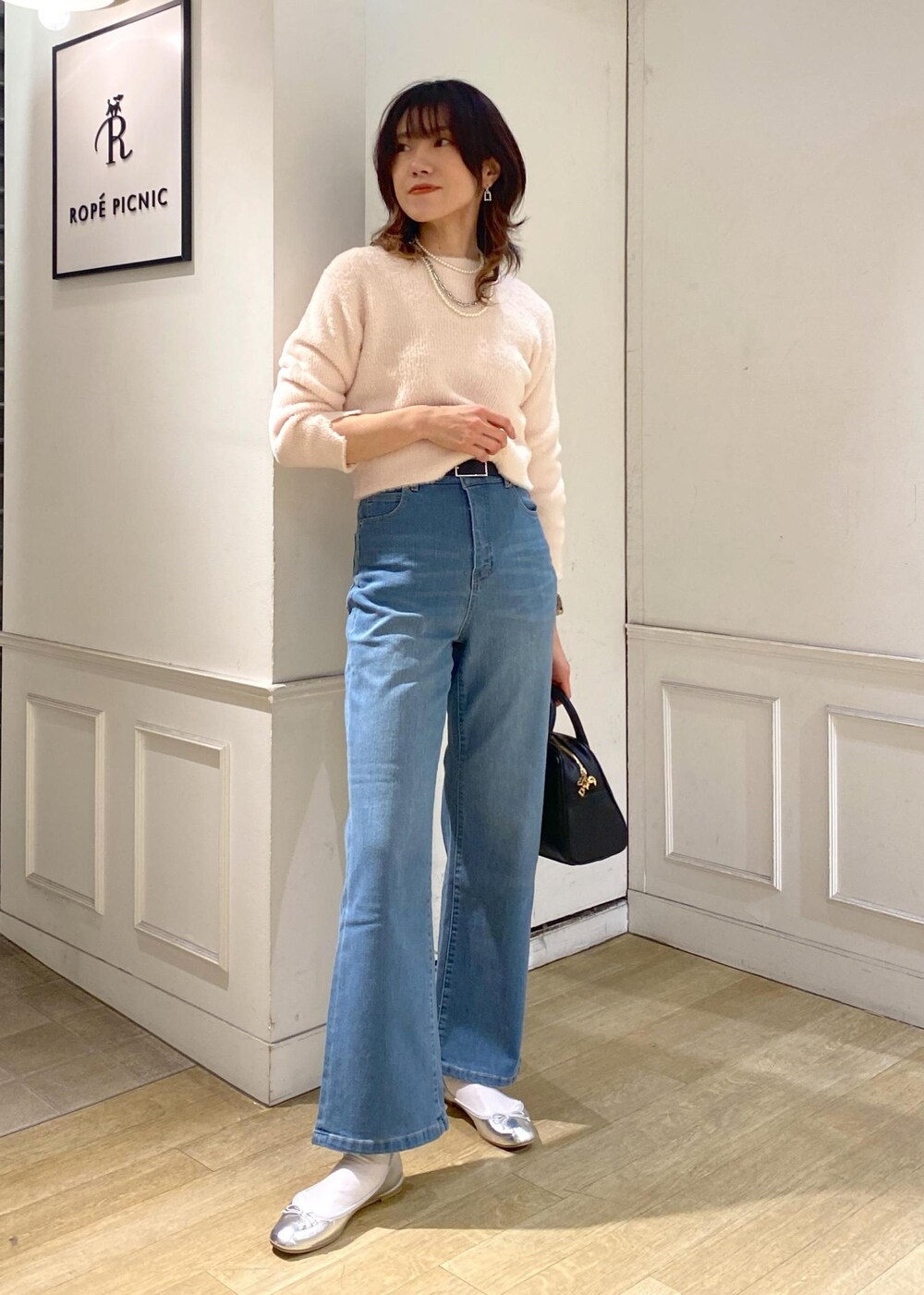 ブルー系のデニムパンツ、ピンク系のカーディガン/ボレロ、ピンク系のニット/セーターを着用したレディースの冬コーディネートの4枚目の写真