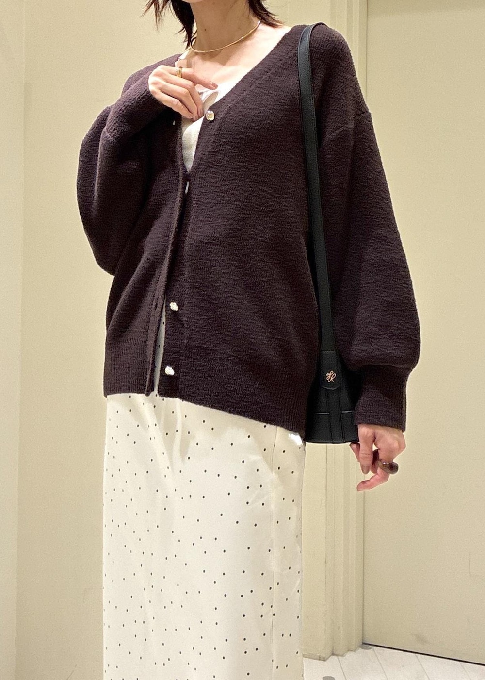 ブルー系のデニムパンツ、ブラック系のパンプス、ブラック系のショルダーバッグを着用したレディースの秋コーディネートの4枚目の写真