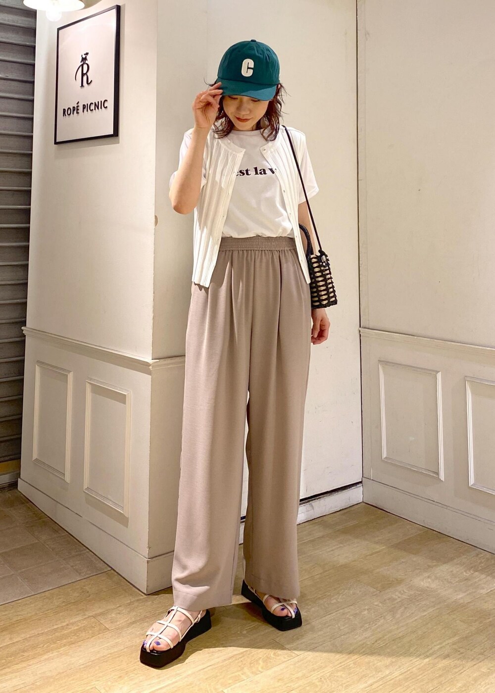 ホワイト系のニット/セーター、ホワイト系のサンダル、ベージュ系のその他パンツを着用したレディースの夏コーディネートの2枚目の写真