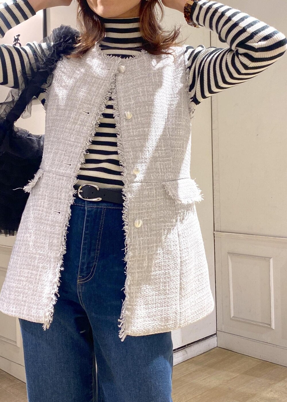 ブルー系のデニムパンツ、ブラック系のベスト、シルバー系のバレエシューズを着用したレディースの冬コーディネートの8枚目の写真